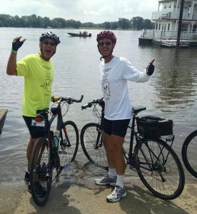 Rod and Dennis Carlson (right) do the official dipping of their front tires in the Mississippi River at Muscatine, Iowa.